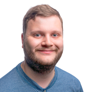 Mann med skjegg og blå genser, smiler mot kameraet. Hvit bakgrunn.