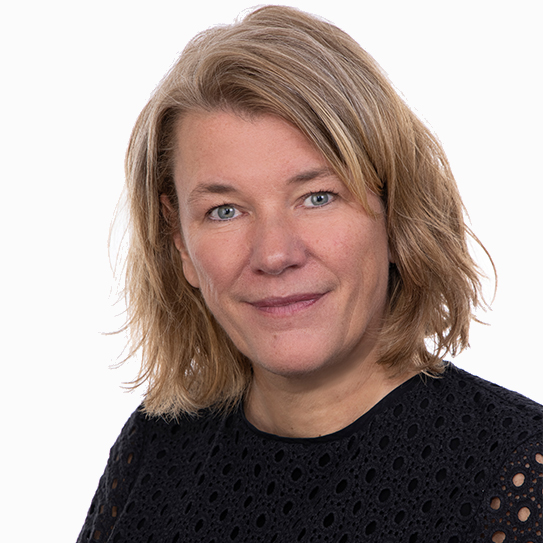 Kvinna med axellångt blont hår och mörk topp ler mot kameran.