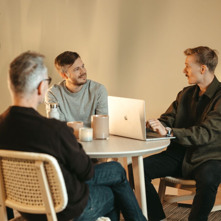 Flera Nordlo medarbetare som sitter runt ett bord och samtalar