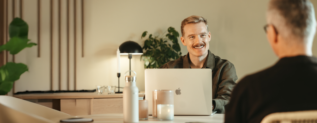 Kontor, två män sitter och pratar framför datorn