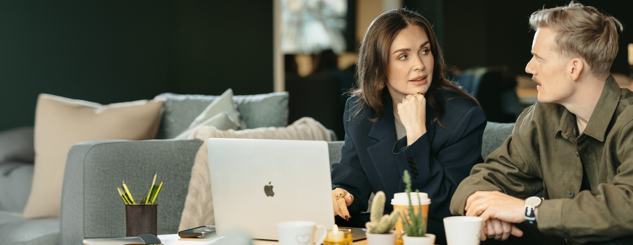 kontor, kvinna och man sitter och pratar framför datorn